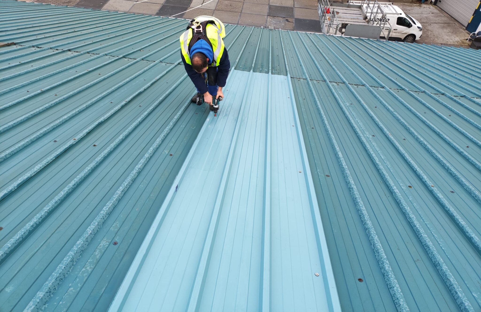 Vakspecialist herstelt dakpanelen op een bedrijfsdak